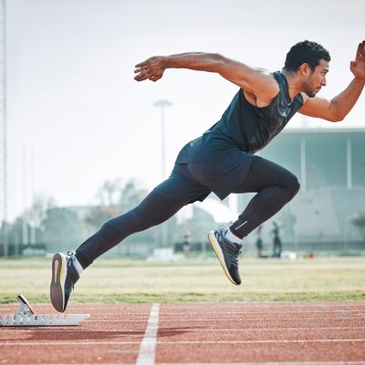 Stadium, man running and athlete on a runner and arena track for sprint race training. Fast, run and sports exercise of a male person in marathon for fitness and workout outdoor on a field for health Stadium, man running and athlete on a runner and arena track for sprint race training. Fast, run and sports exercise of a male person in marathon for fitness and workout outdoor on a field for health.