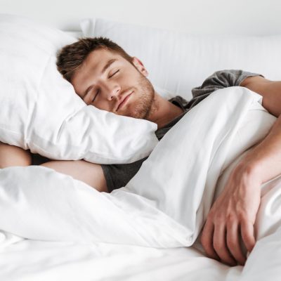 Handsome young man sleeping in bed Handsome young man sleeping in bed at home
